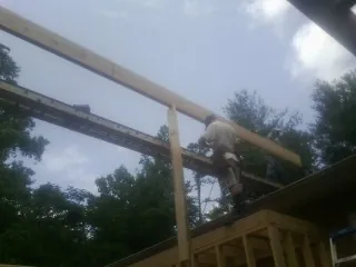 Carpenter setting a ridge beam over a new addition frame — Ice Dam Removal by Roofing Brothers in Herrick